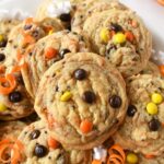 A plate of baked yellow, orange, and brown candy cookies on a platter.