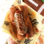 A sausage sub with melted and bubbly provolone on it.