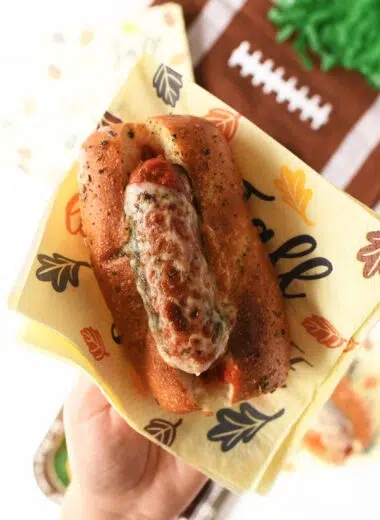 A sausage sub with melted and bubbly provolone on it.