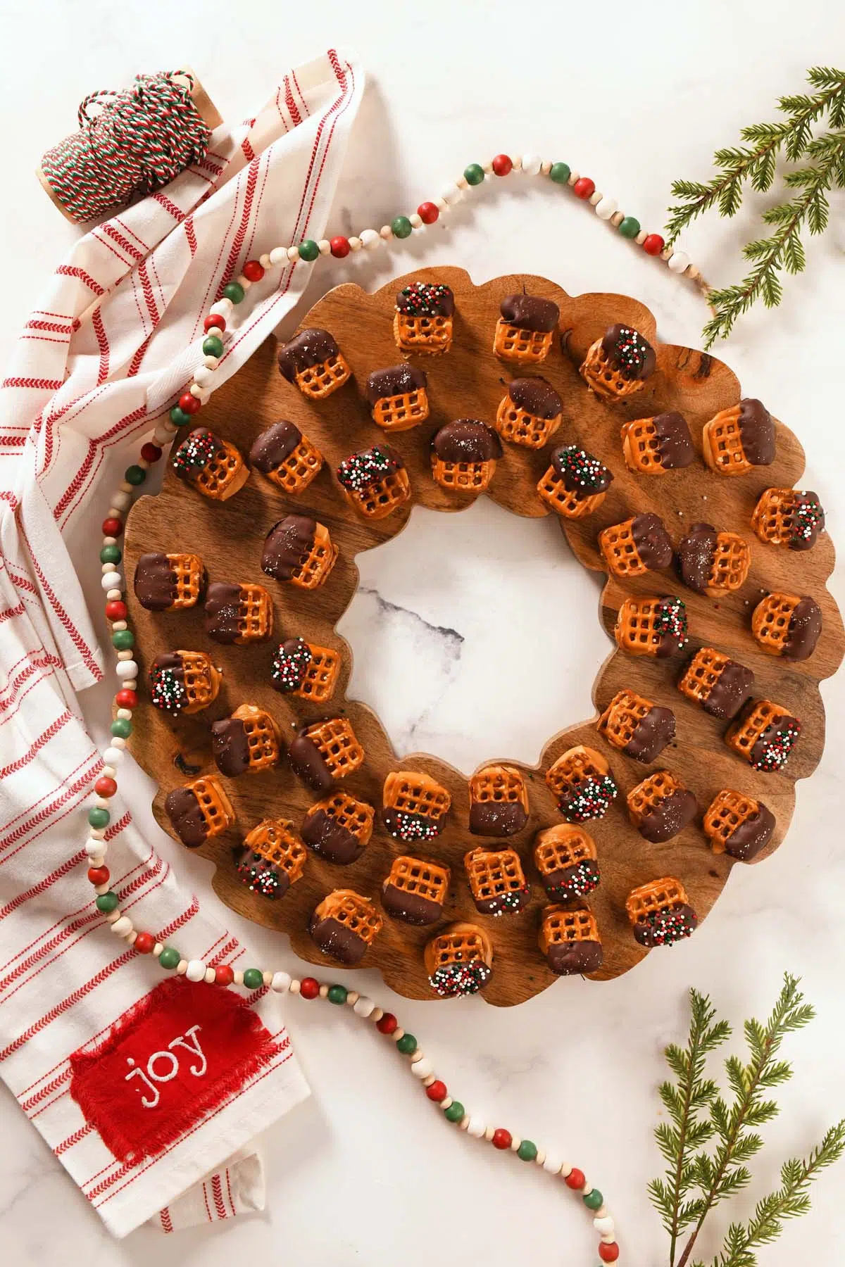 A wooden wreath with Pretzel bites on it.