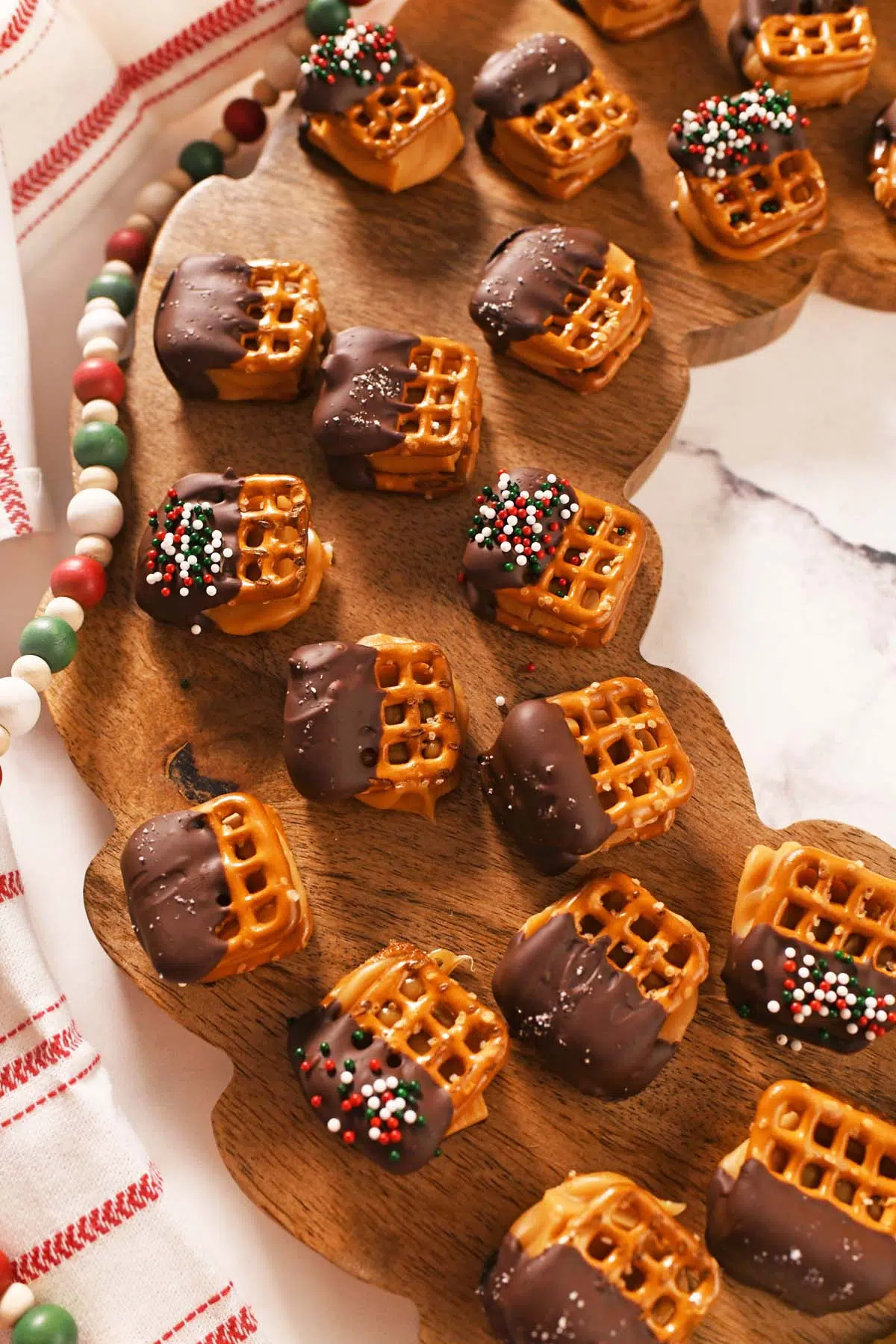 A close up of caramel pretzel bites on a wooden wreath.