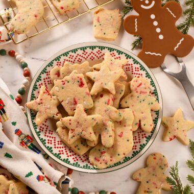 A Christmas plate of cookies with a gingerbread spatula.