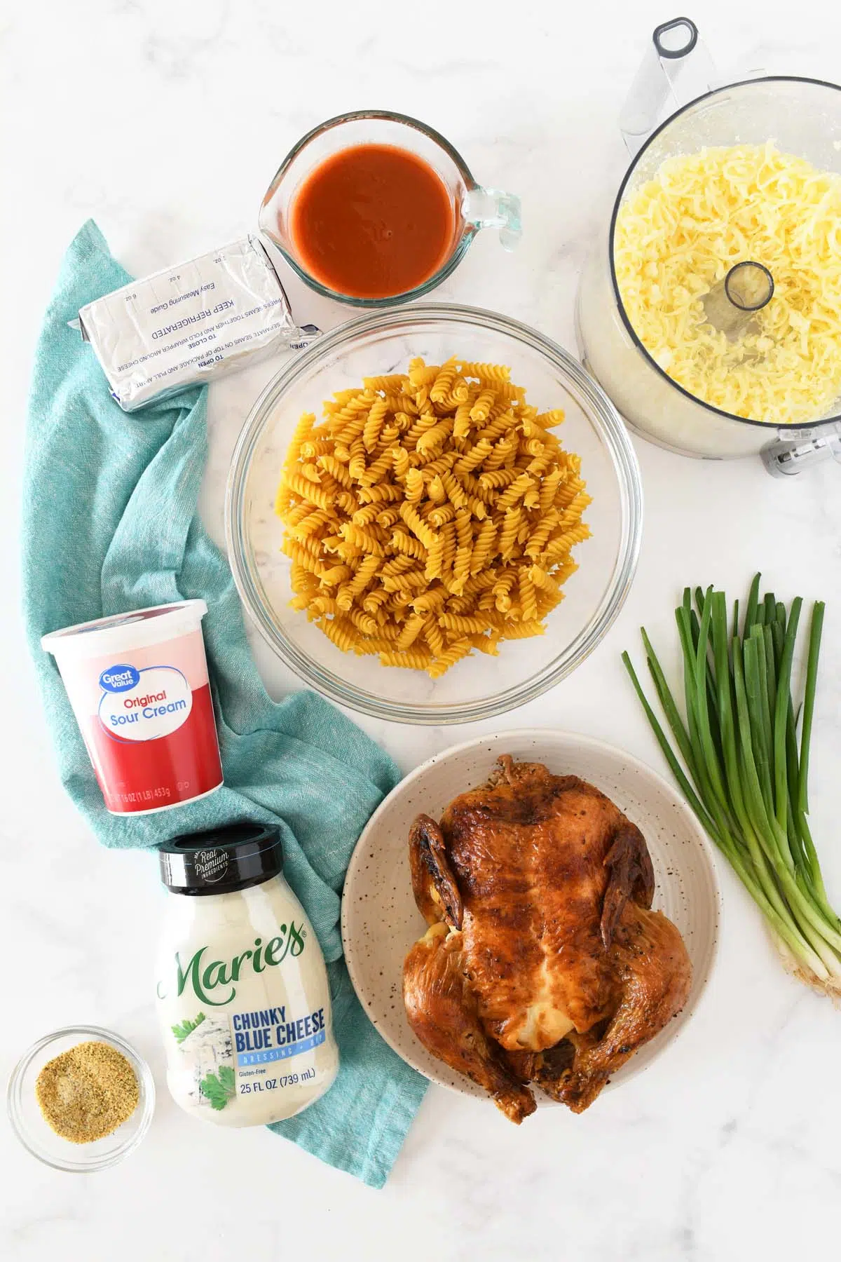 rotisserie chicken buffalo pasta ingredients on a white table.