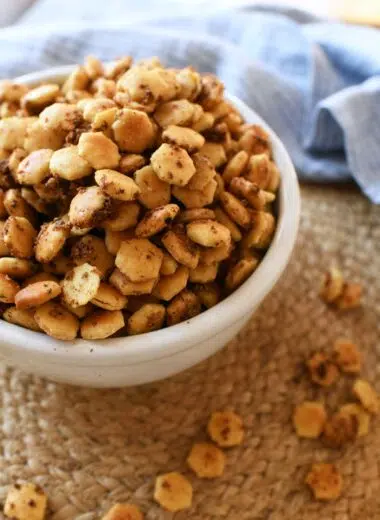 A bowl of seasoned oyster crackers with a blue napkin.
