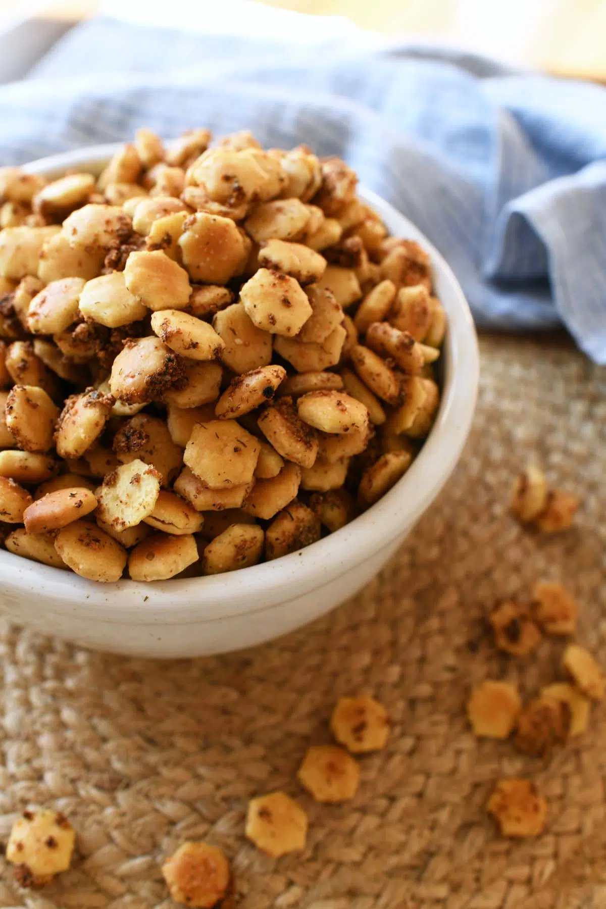 A bowl of seasoned oyster crackers with a blue napkin.