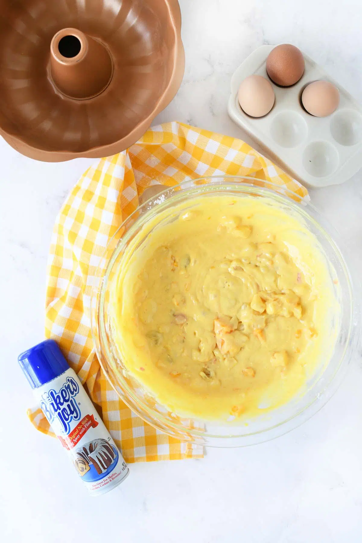 Fruit cocktail bundt cake batter in a glass bowl.