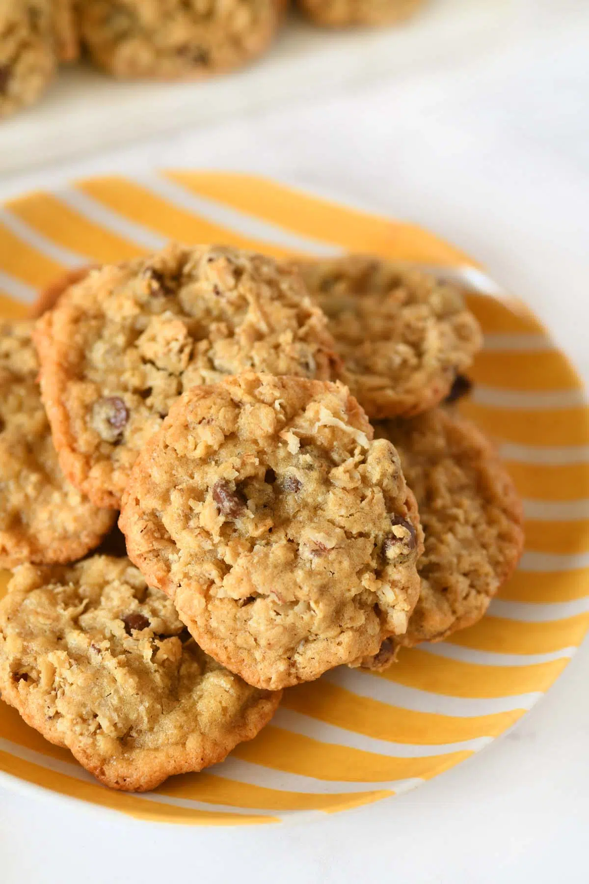 A yellow striped plate with cowboy cookies on it.