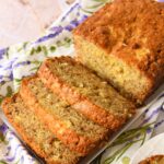 Sliced pineapple banana bread on a white plate wiht a floral napkin.