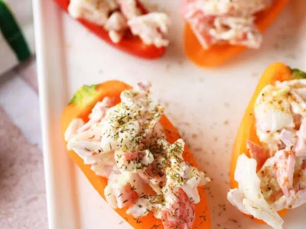 Seafood salad stuffed peppers on a white plate.