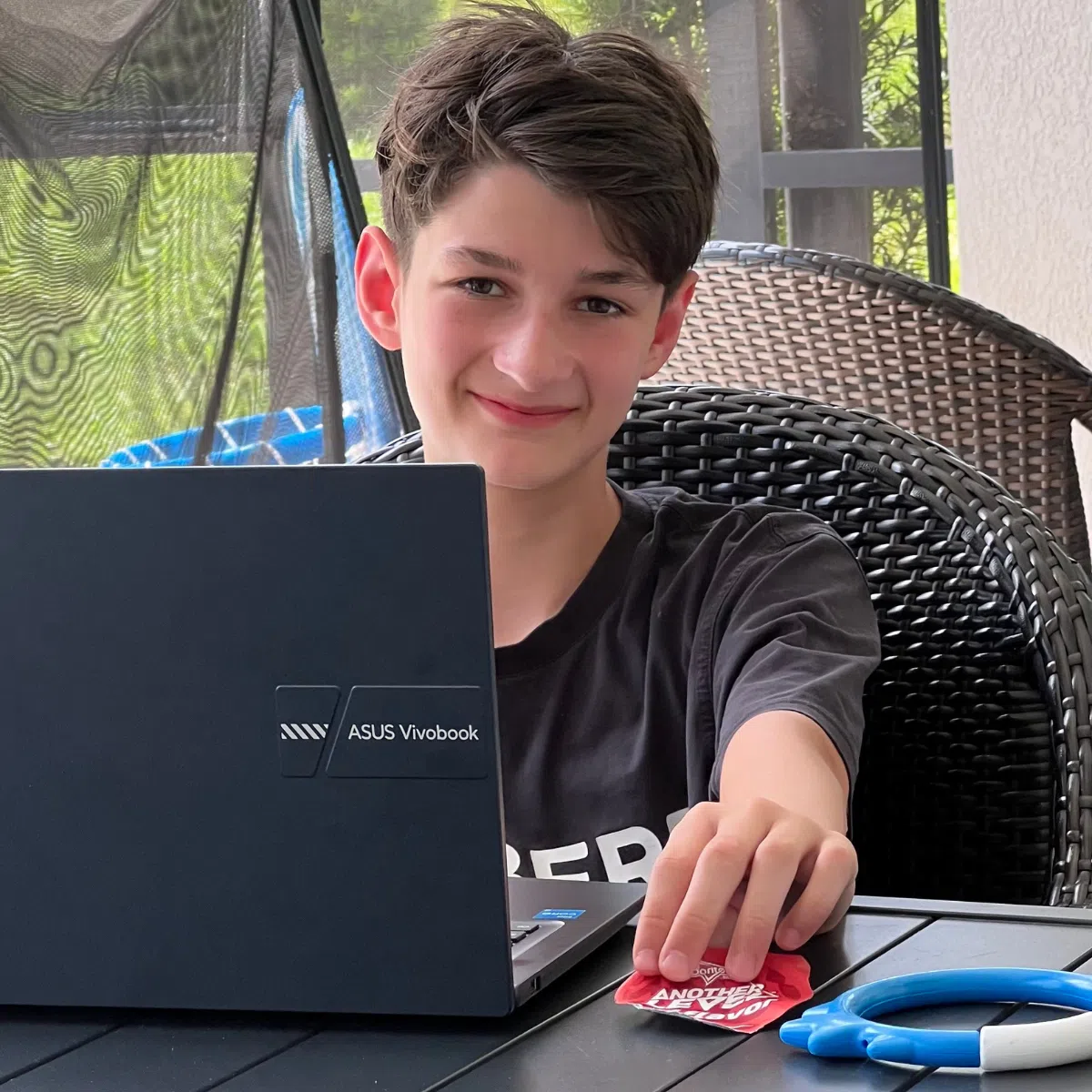 A boy outside on his computer