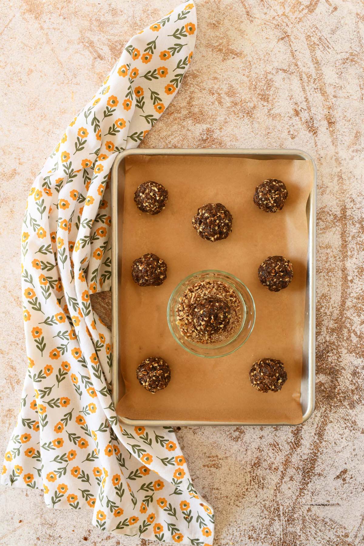 Pecan energy ball on a parchment-lined baking sheet.