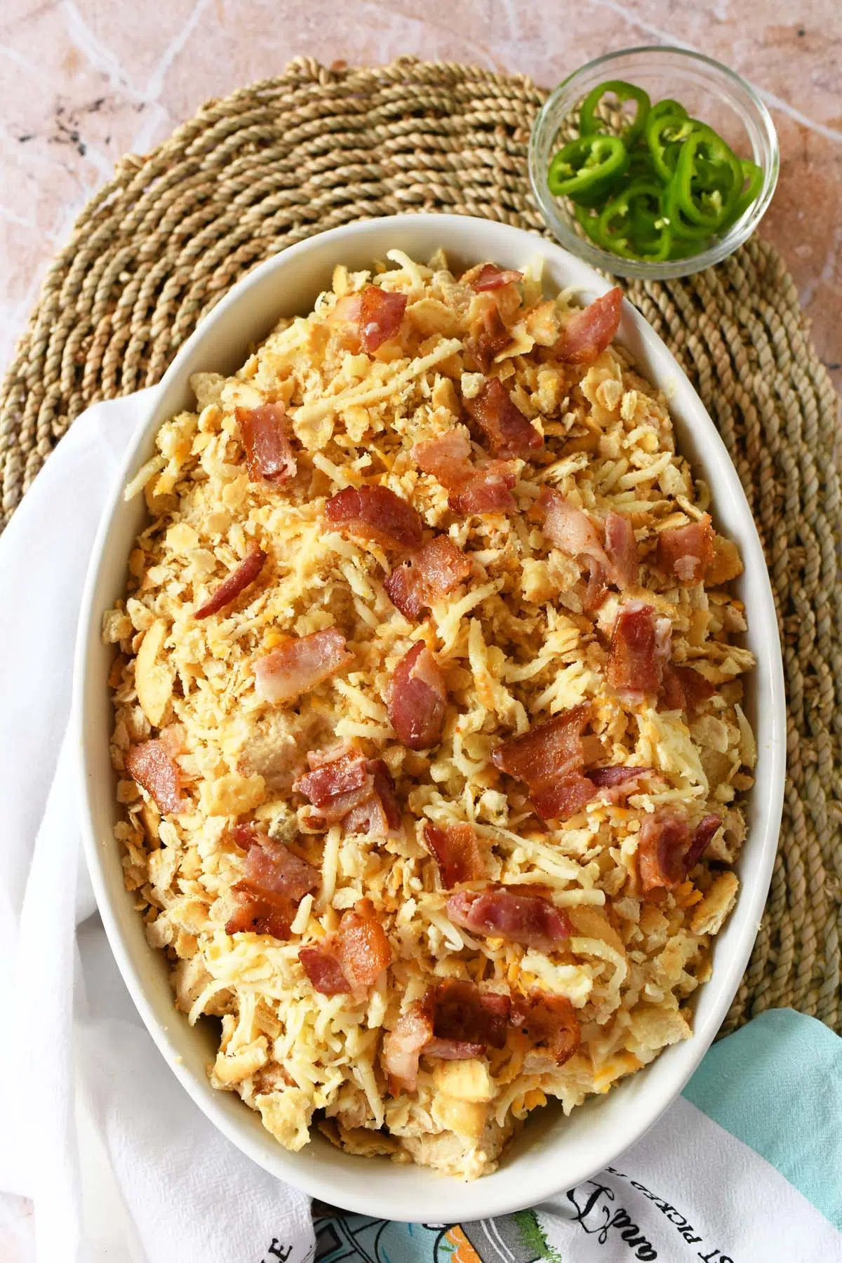 Unbaked jalapeno popper chicken in an oval baker.