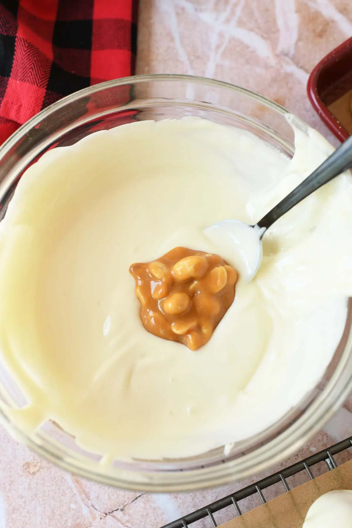 A caramel peanut cluster in white, melted chocolate.