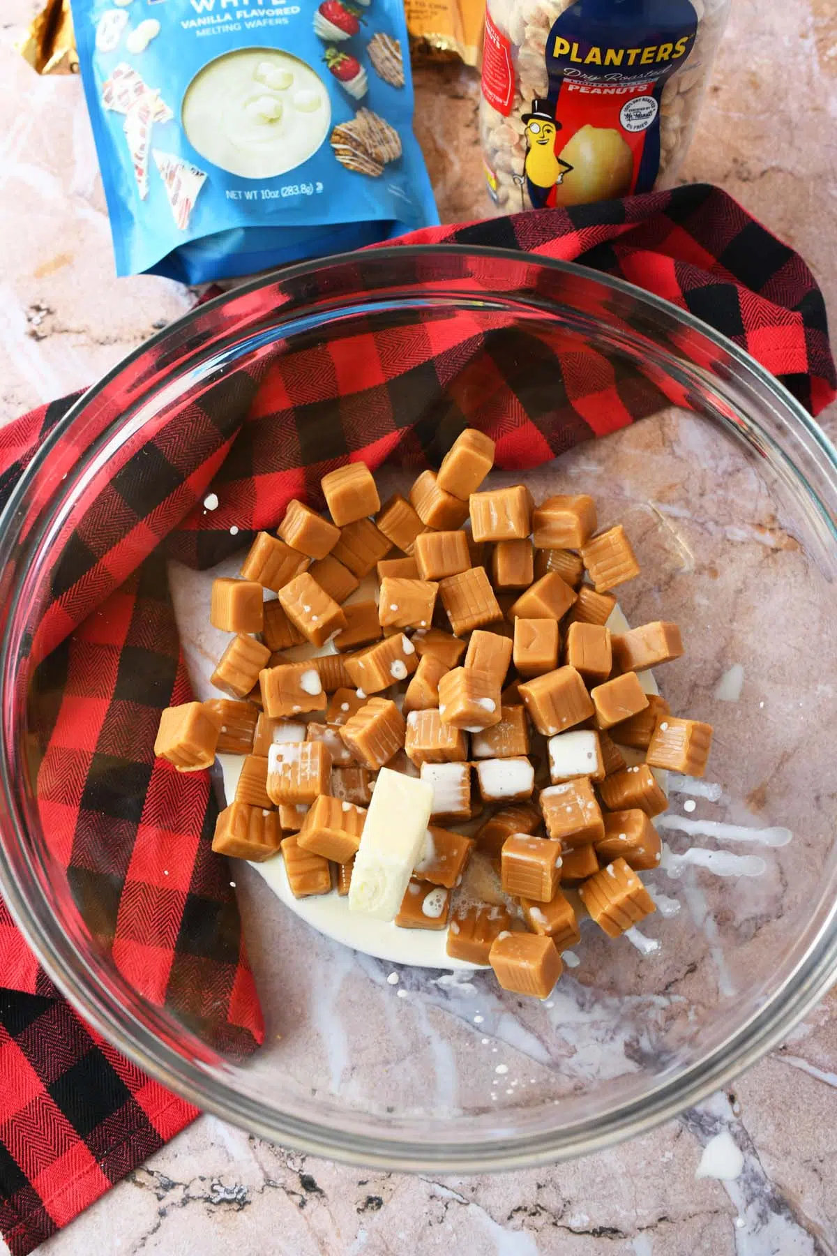 Caramel squares with cream and butter in a glass bowl.