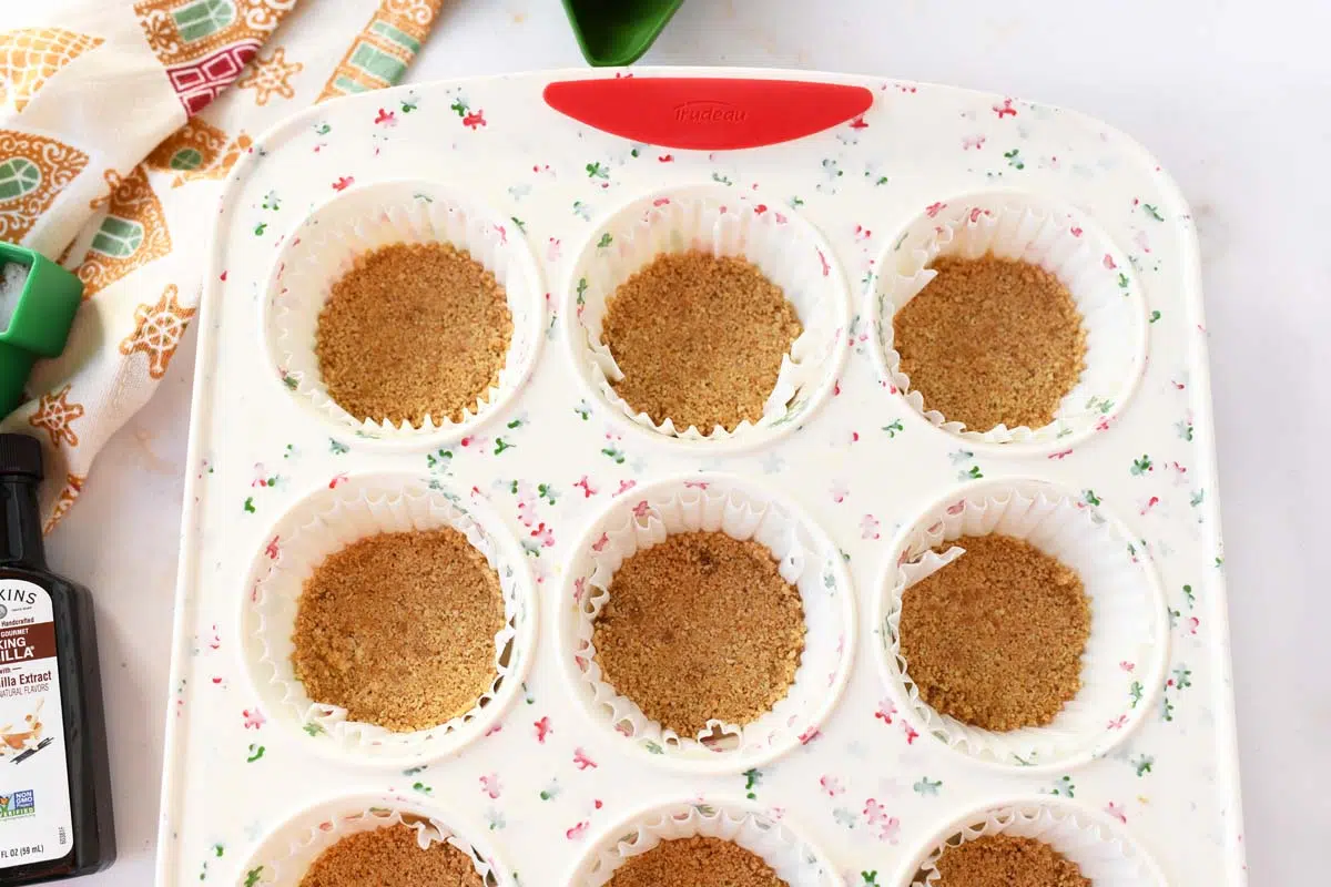 Graham cracker crust in silicone holidya muffin tin wells.