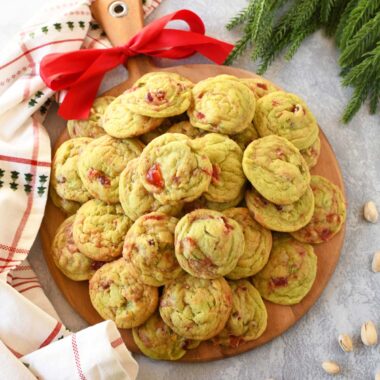 A tray of pistachio cherry cookies with a red bow.