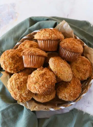sourdough coffee cake muffins in a basket near a green napkin.