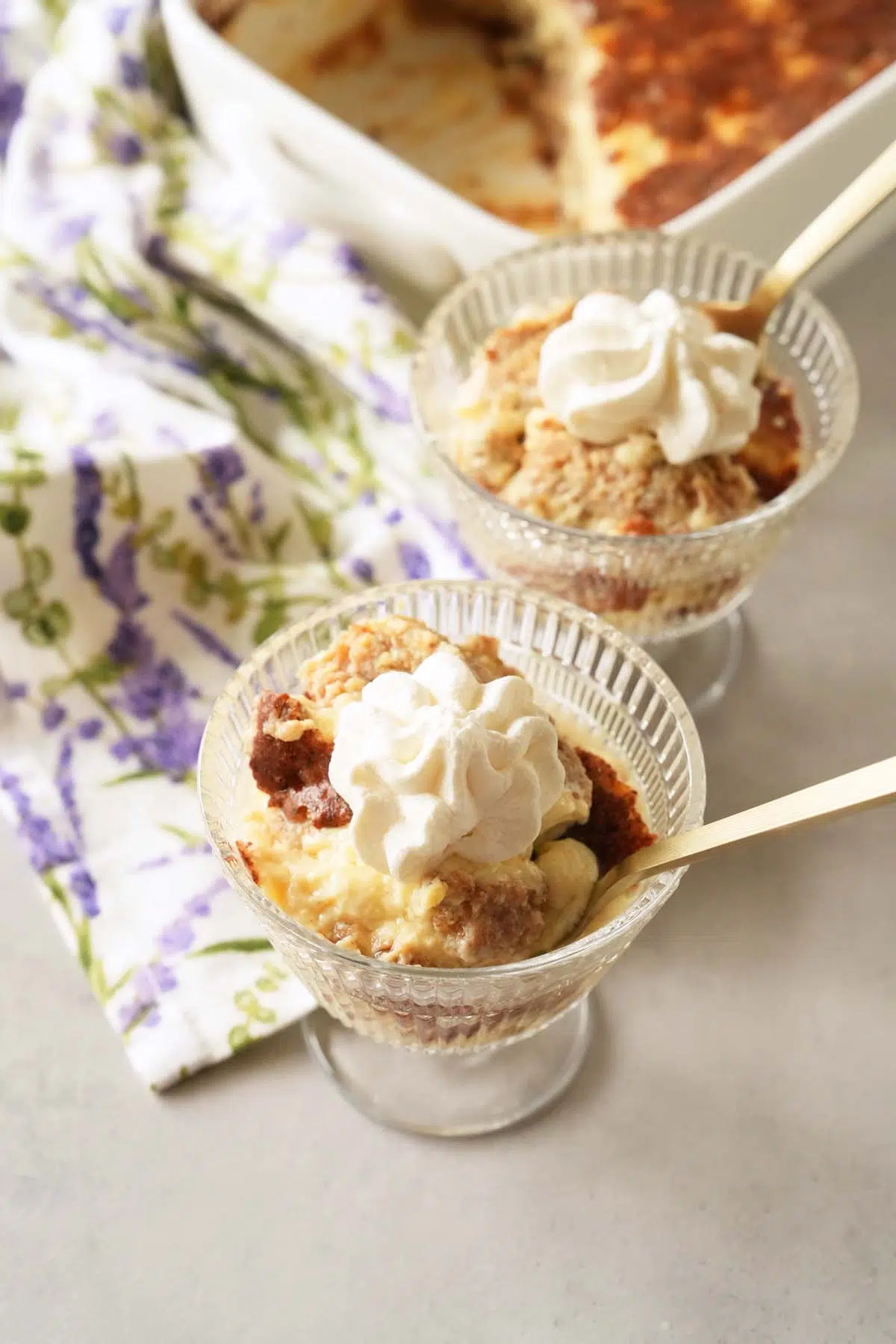 Two glass dishes of Grape-Nuts pudding with dollops of whipped cream.