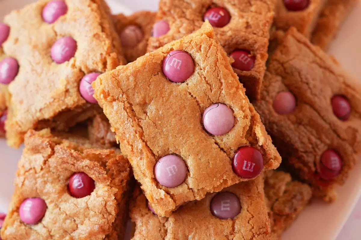 Up close shot of a golden-brown valentine's day blondie with M&Ms inside.