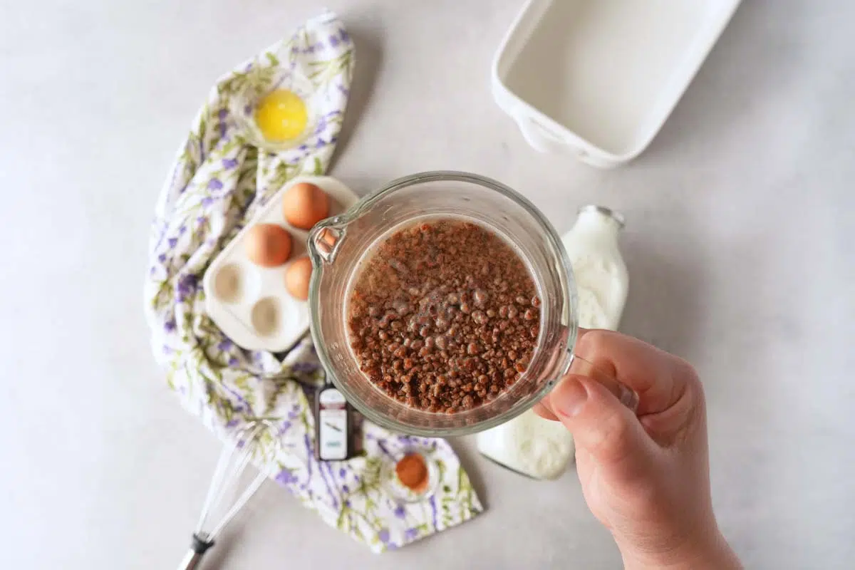 A hand holding soaked Grape-Nuts in water.