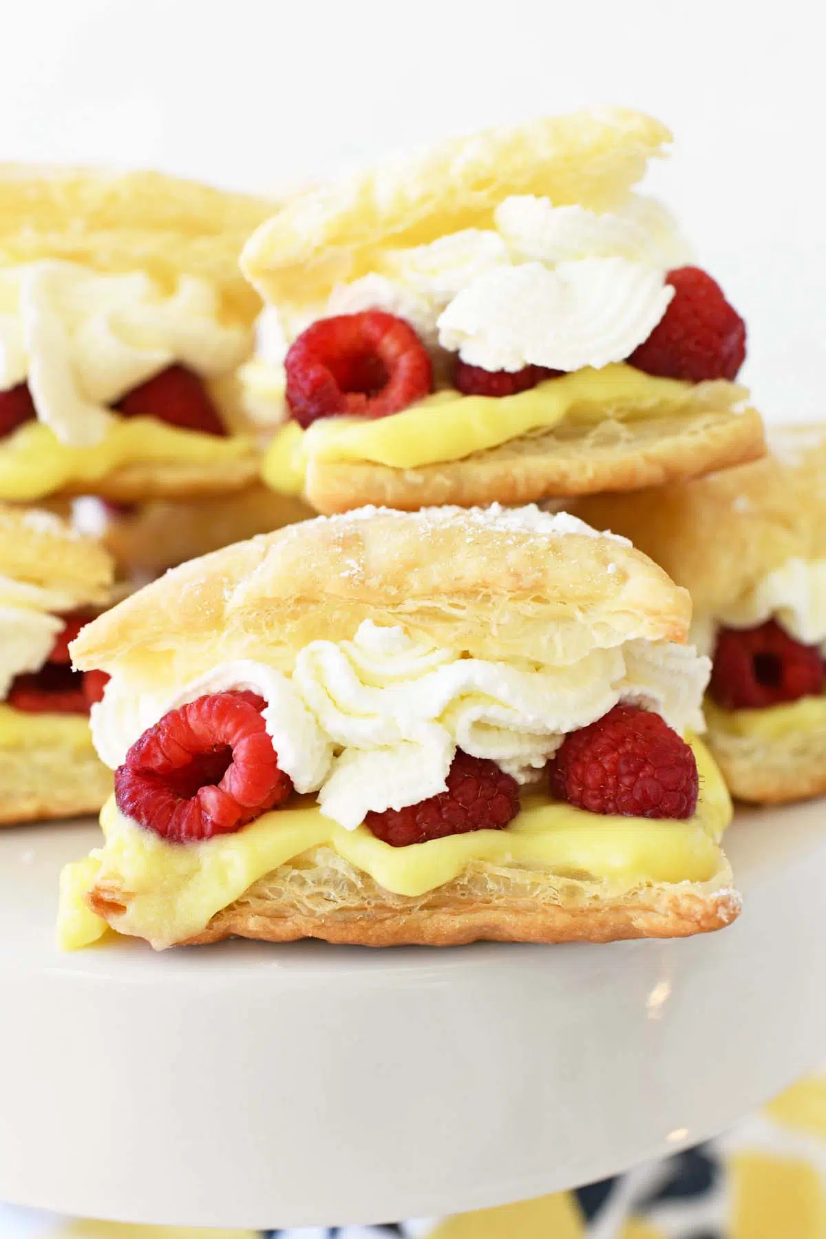 Cream puffs filled with raspberries, lemon pudding, and whipped cream on a platter.
