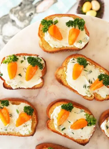 Carrot patch toasts appetizer on white, marble tray.