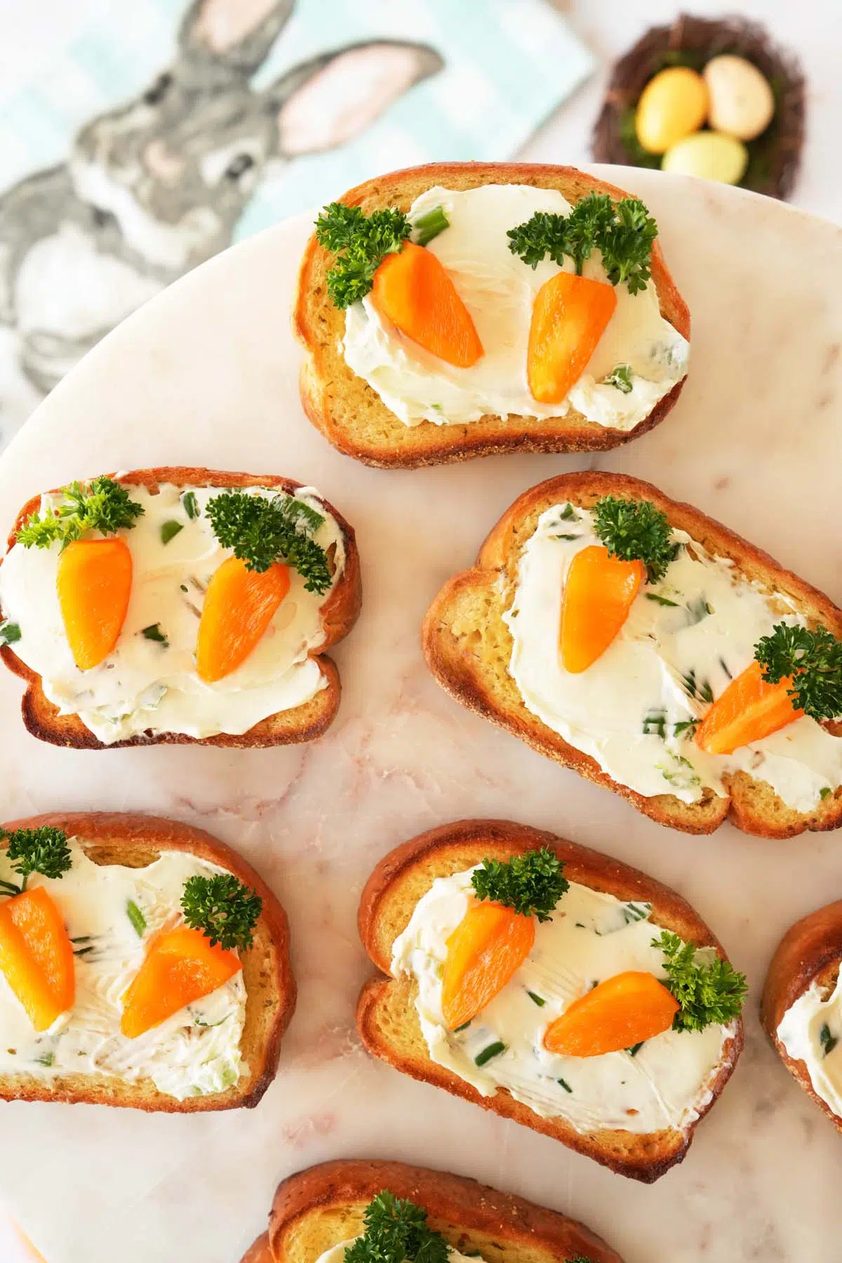 Carrot patch toasts appetizer on white, marble tray.