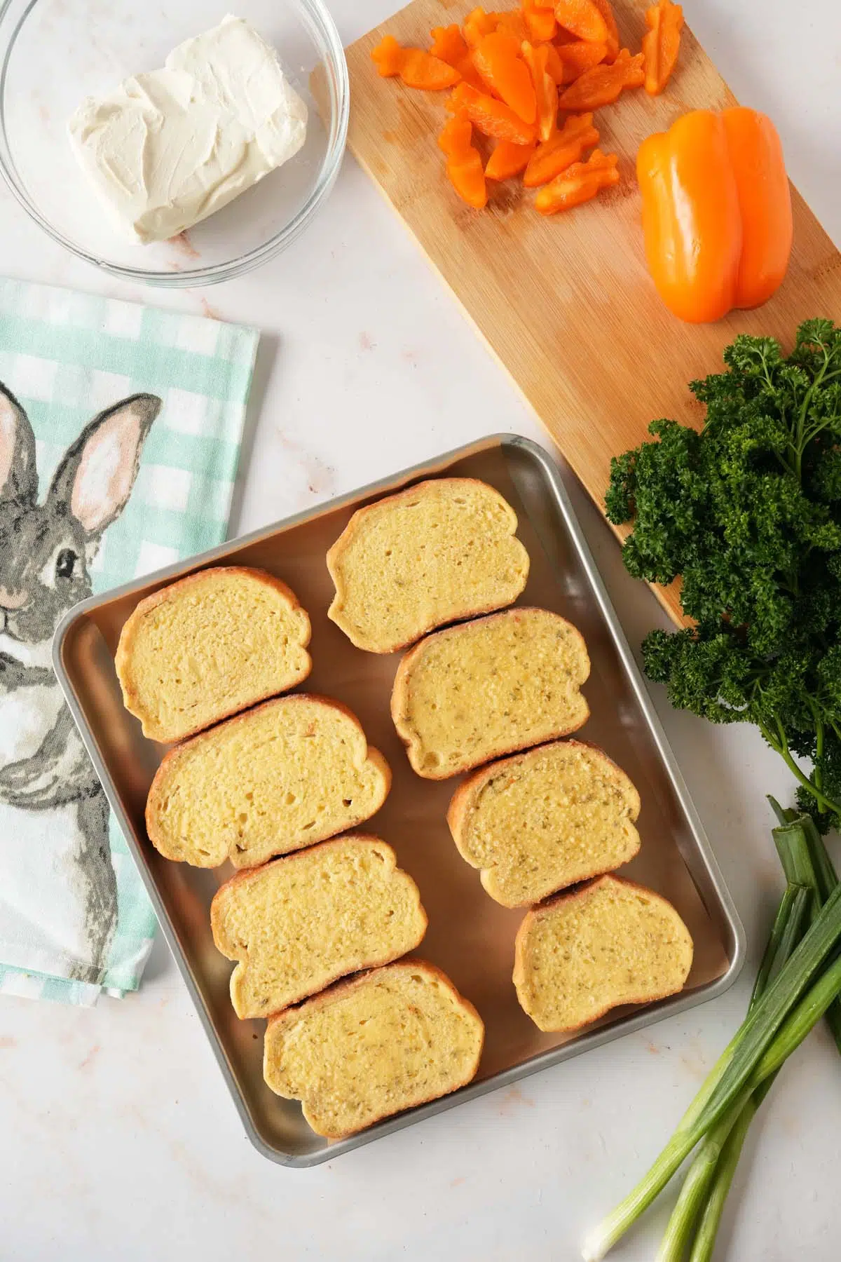 Texas Toasts on an air fryer tray with fresh ingredients nearby.
