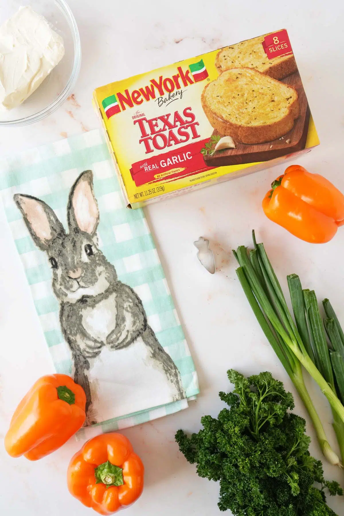 Carrot patch texas toasts ingredients on a white table near a bunny napkin.