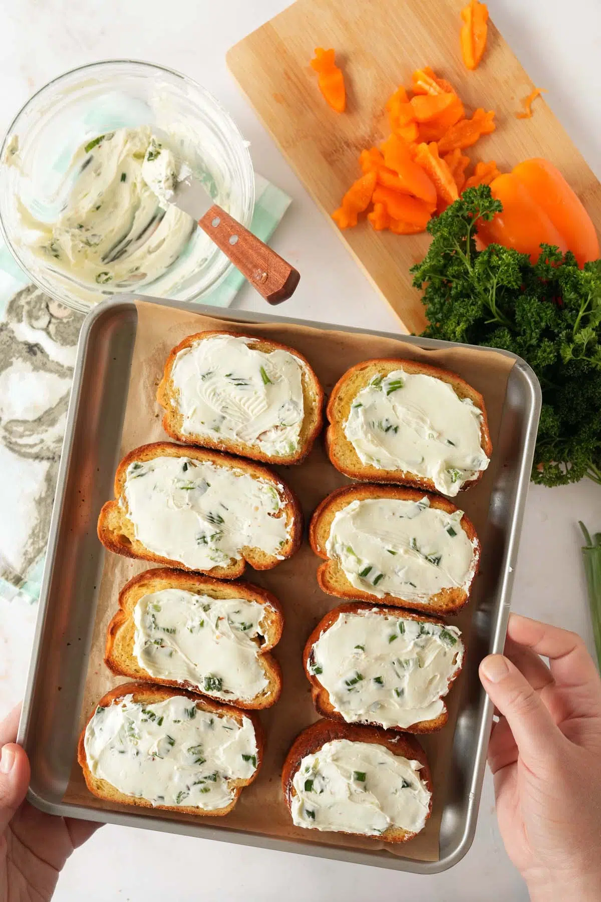 Hands holding a tray of air fried Texas Toasts with cream cheese spread.