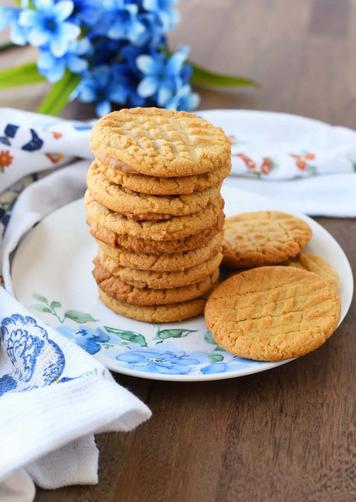 A stack of peanut butter cookies on a blue, floral plate.
