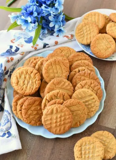 Peanut butter cookies on a blue plate with blue flowers and a napkin nearby.