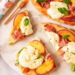 Sliced Peach flatbread with peach slices, ham, basil, and a drizzle of hot honey.
